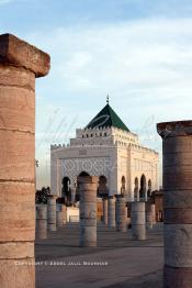 Image du Maroc Professionnelle de  Le tombeau du plus populaire des sultans du Maroc, Mohammed V, père de l’indépendance repose ici dans cette  demeure bâtie en marbre blanc et couronnée par un toit pyramidale orna de tuiles vertes, symbole de la royauté. Sa construction a nécessita une dizaine d’année, au premier plan  les colonnes de l’esplanade de la Mosquée Hassan à Rabat, Jeudi 1er Mars 2007. (Photo / Abdeljalil Bounhar)
